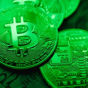 Close-up of green-illuminated Bitcoin coins representing digital currency and blockchain technology.